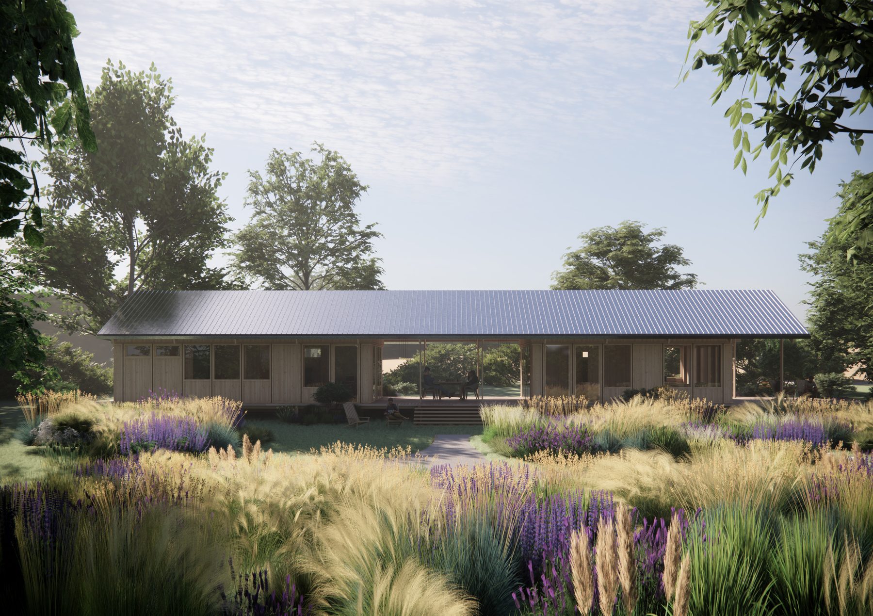 Single-storey timber house with a covered terrace in a meadow at dusk